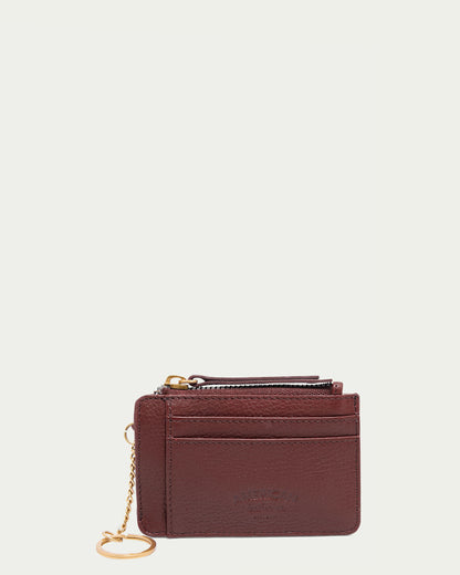 The Portland Wallet With RFID by American Leather Co. features an elegant cordovan design, multiple card slots, and embossed text on the front. Made from premium glove-tanned leather, its allure is highlighted against a simple white background.