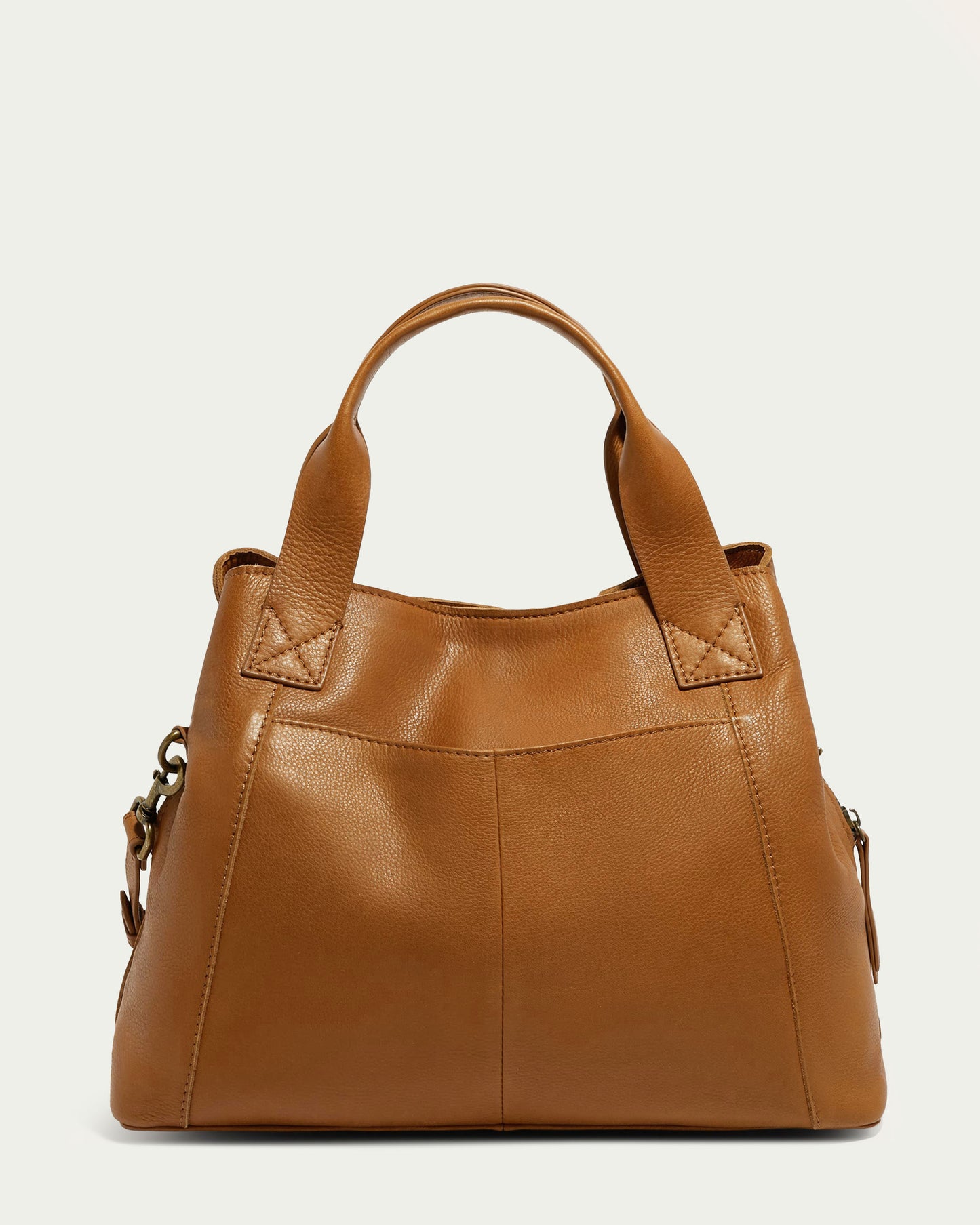 The Ada Triple Entry Satchel by American Leather Co. is a brown leather handbag made from genuine leather, featuring short handles and a minimalist design. This structured satchel offers a smooth texture with visible stitching and side compartments for extra storage, set against a plain light background.