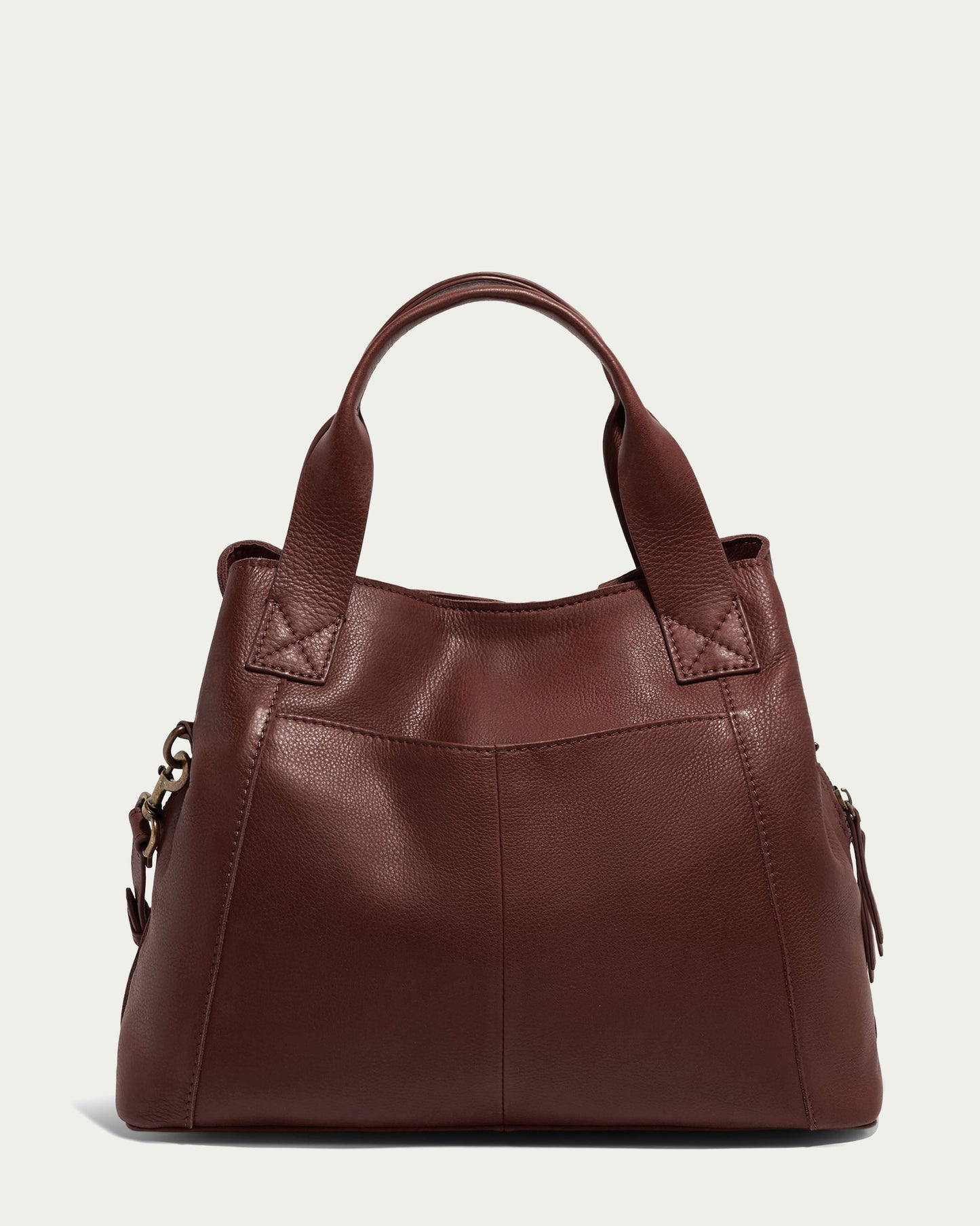 Introducing the Ada Triple Entry Satchel by American Leather Co., a brown leather structured bag with short handles, boasting a simple and sleek design. This satchel has a slightly rounded shape, subtle stitching details, and is crafted from Genuine American Leather. The background is plain and light-colored.