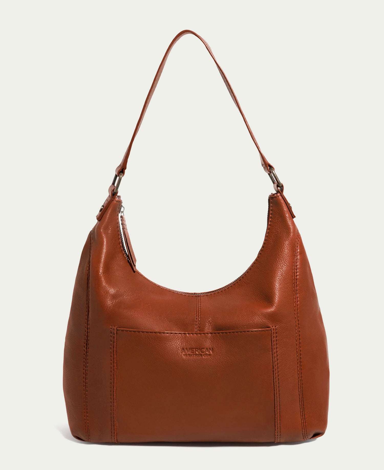 American Leather Co.'s Blake Hobo is a brown leather bag with a single shoulder strap, front pocket, minimalist design, visible stitching, and secure zipper closure—ideal for daily use.