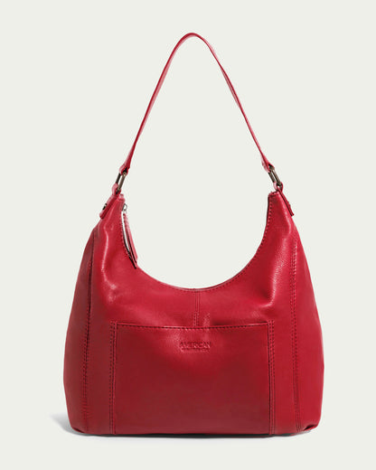 The Blake Hobo by American Leather Co. is a red leather bag with a single shoulder strap and front pocket, crafted from genuine leather with a smooth finish and visible stitching, showcasing its functional design.