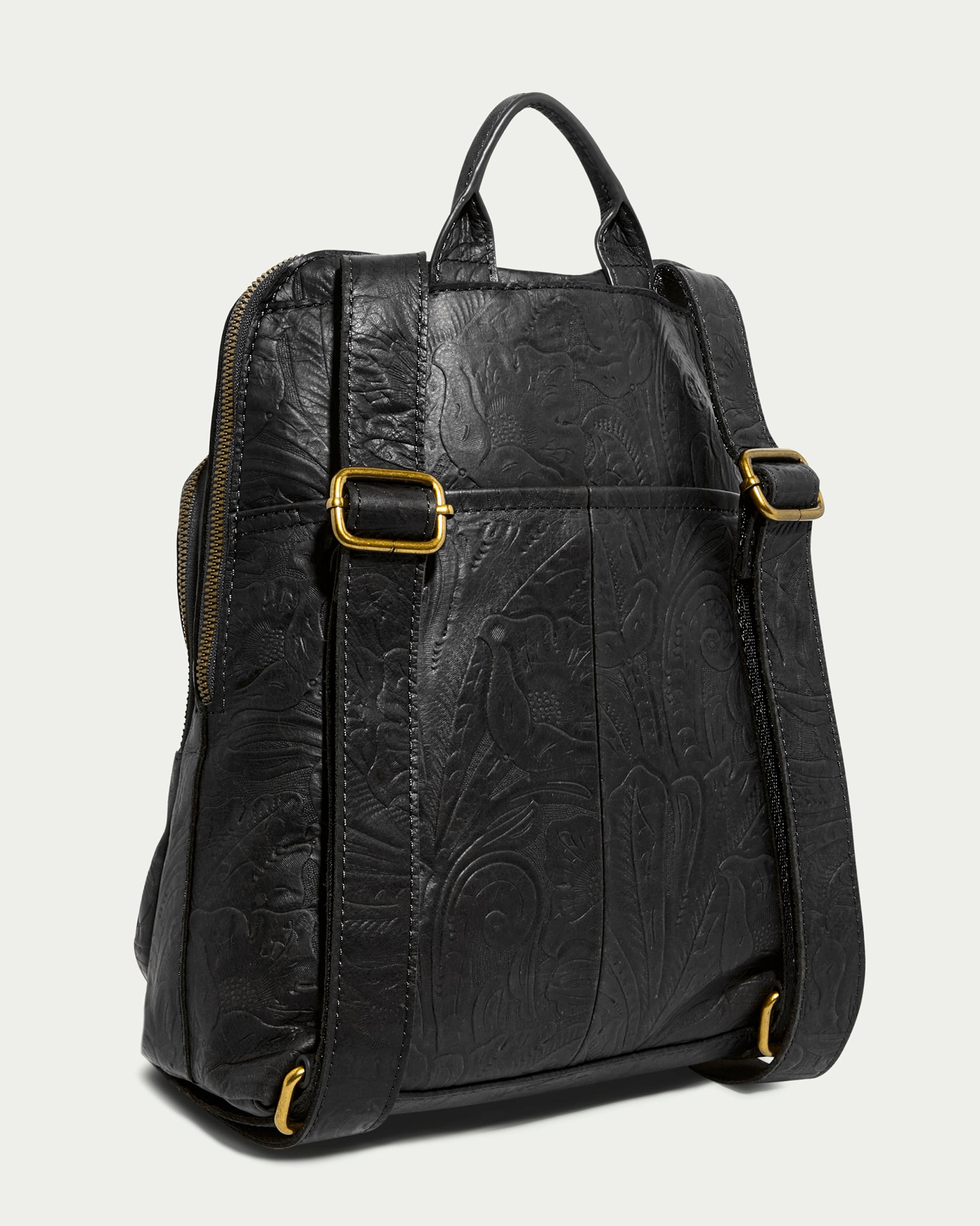 The Cleveland Backpack by American Leather Co. is a black leather backpack made from genuine American leather, showcasing intricate embossed bird and nature patterns. It features gold-tone buckle accents on adjustable back straps and a durable top handle.