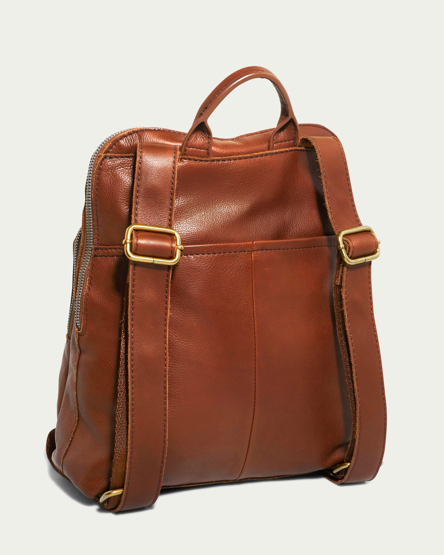 Introducing the Cleveland Backpack by American Leather Co. This brown leather backpack purse features gold buckle adjusters on its straps. Crafted from genuine American leather, it boasts a smooth, polished texture and is shown from the back, highlighting the adjustable, padded shoulder straps and a top carrying handle.