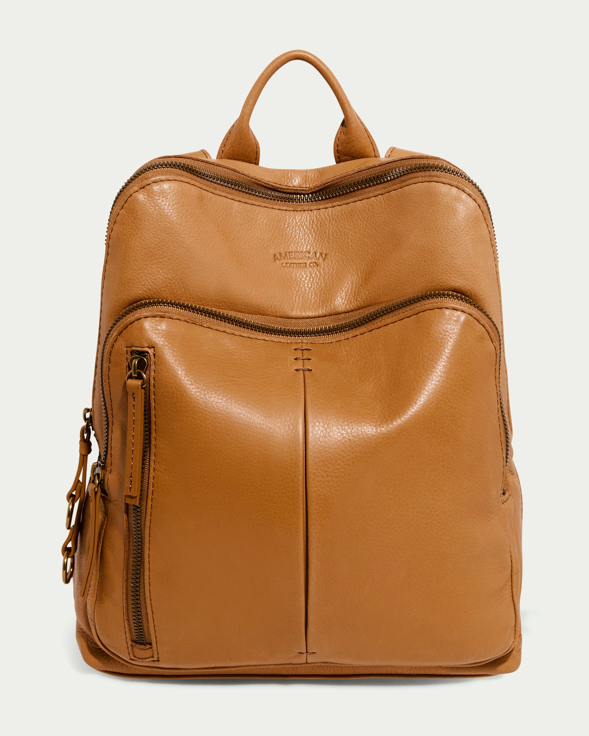 The Cleveland Backpack by American Leather Co. is a women's leather backpack made from genuine American leather. It has a top handle, adjustable back straps, multiple zippered compartments, a front left-side pocket with zipper, a small metal charm, and a slightly glossy finish.