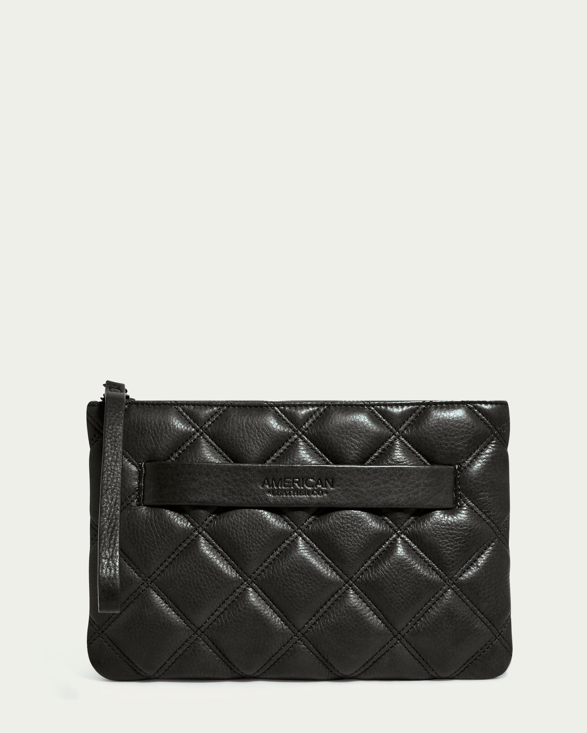 The Emerson Quilted Wristlet by American Leather Co. is a sleek, black clutch made from textured quilted leather. It features a wristlet strap and subtle embossing of "AMERICAN" in the center, embodying modern design elegance.