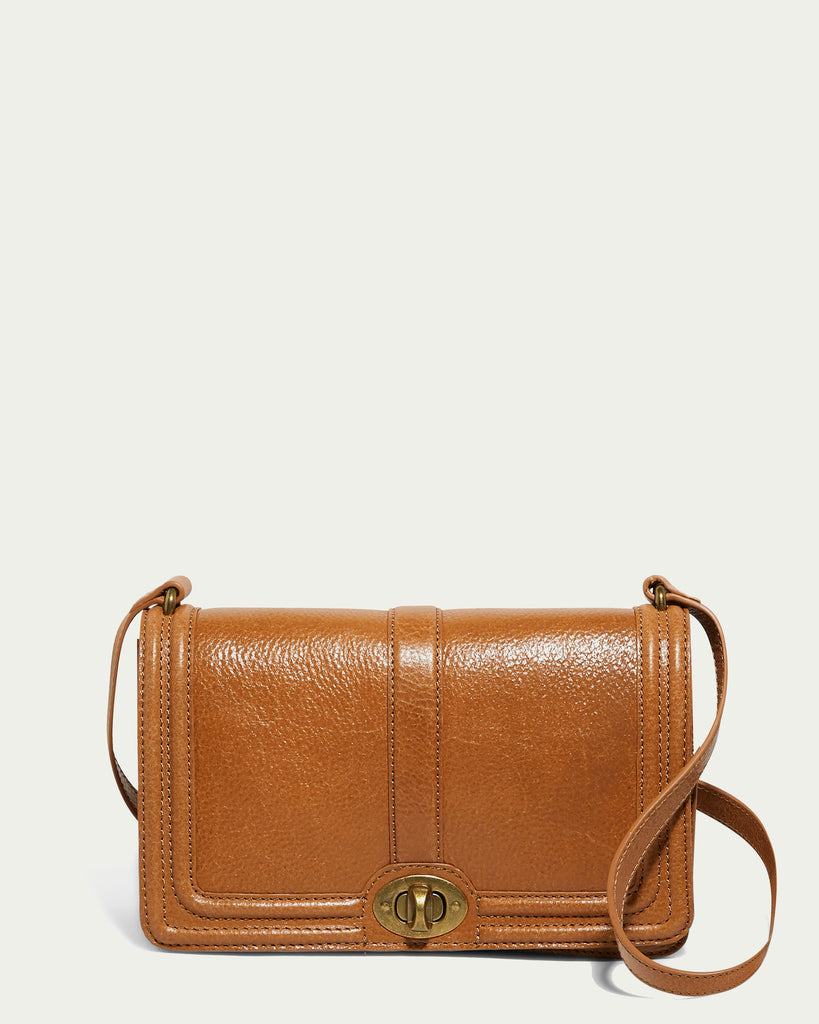 Introducing the Becky Crossbody by American Leather Co., a stylish vintage leather shoulder bag in a rich brown color with a textured finish. It features an elegant gold-tone clasp on the front flap and comes with a matching leather strap. This crossbody bag effortlessly blends timeless elegance with modern functionality.