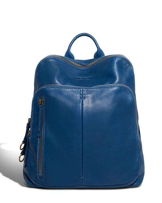 The Cleveland Backpack by American Leather Co. is a sleek blue leather design made from genuine American leather. It features a single top handle, two adjustable back straps, a front zippered pocket, and a main compartment with a top zipper closure, all showcased on a plain white background.