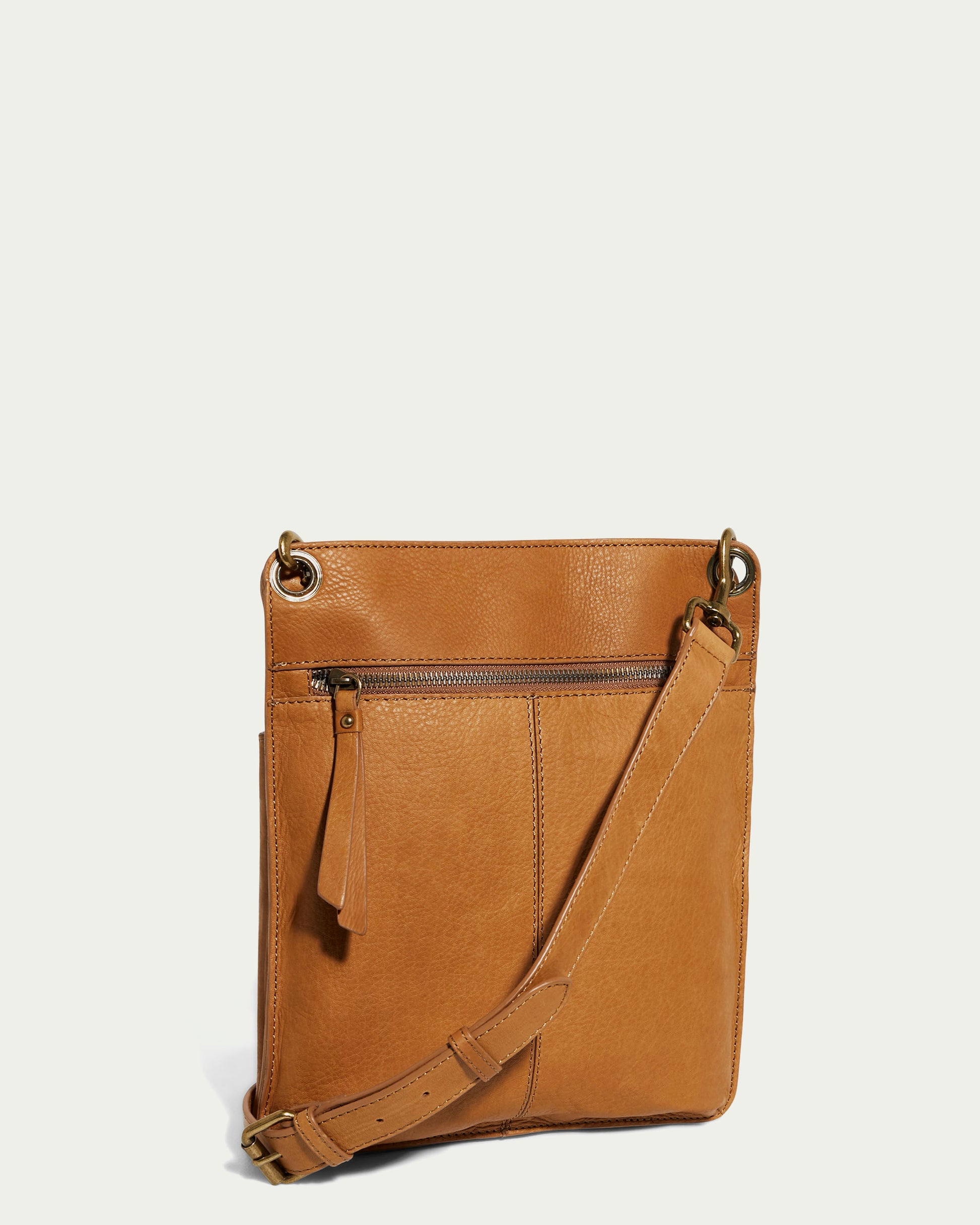 The Lily Multi Compartment Crossbody by American Leather Co. is a chic accessory made from genuine leather, featuring a long adjustable strap and front zip pocket with accent stitching, all set against a plain, light background in stylish brown.