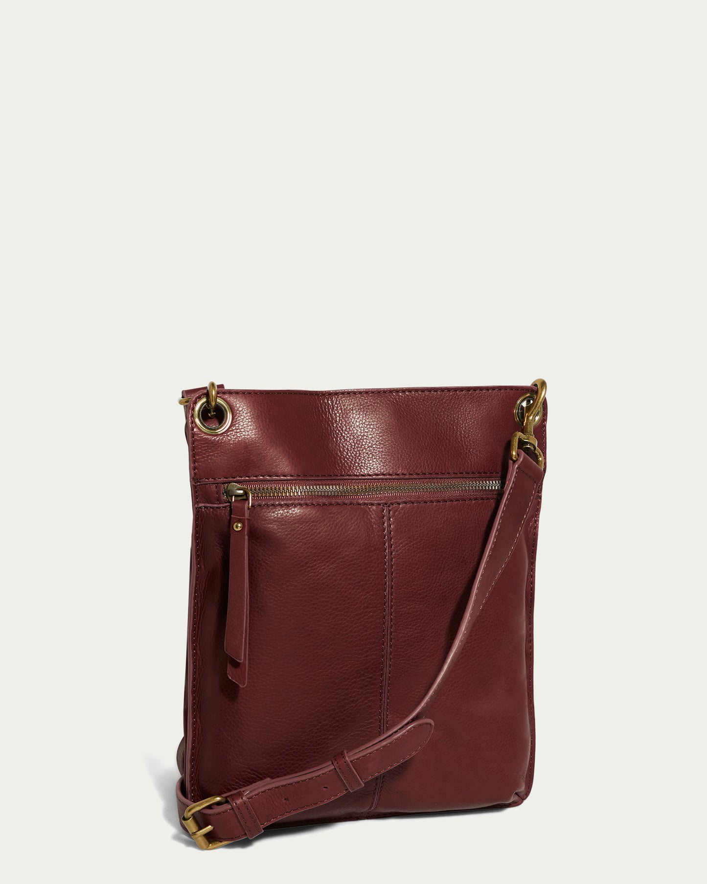 The Lily Multi Compartment Crossbody by American Leather Co. is a chic accessory made from genuine American leather in maroon with gold hardware, featuring a zippered front pocket and an adjustable strap against a plain, light background.