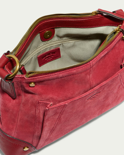 The Becket Triple Entry Shoulder from American Leather Co. is displayed from a top angle, showcasing its spacious beige interior enhanced by a small red leather tag. This classic shoulder bag, crafted from Genuine Leather, features a zippered closure, gold-tone hardware, and an exterior slip pocket. The design also offers the added convenience of triple entry compartments.