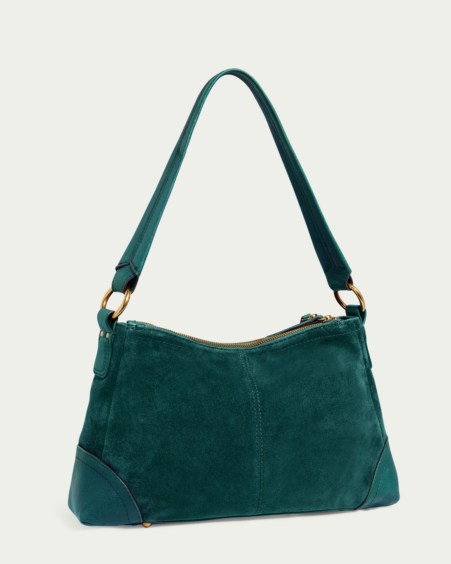 The Becket Triple Entry Shoulder by American Leather Co. is a genuine suede leather shoulder bag in forest green with gold hardware, a zippered top closure, reinforced corners, and a single strap attached with metal rings. The backdrop is light beige.