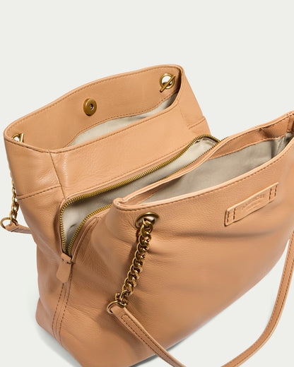 The Brisben Chain Shopper by American Leather Co. is a genuine leather handbag in peach, featuring gold chain straps and a magnetic snap closure. Its open design reveals a light beige interior lining with multiple compartments and a zippered pocket. This lightweight chain handbag also includes a small label on the front, making it the perfect stylish triple entry shopper.