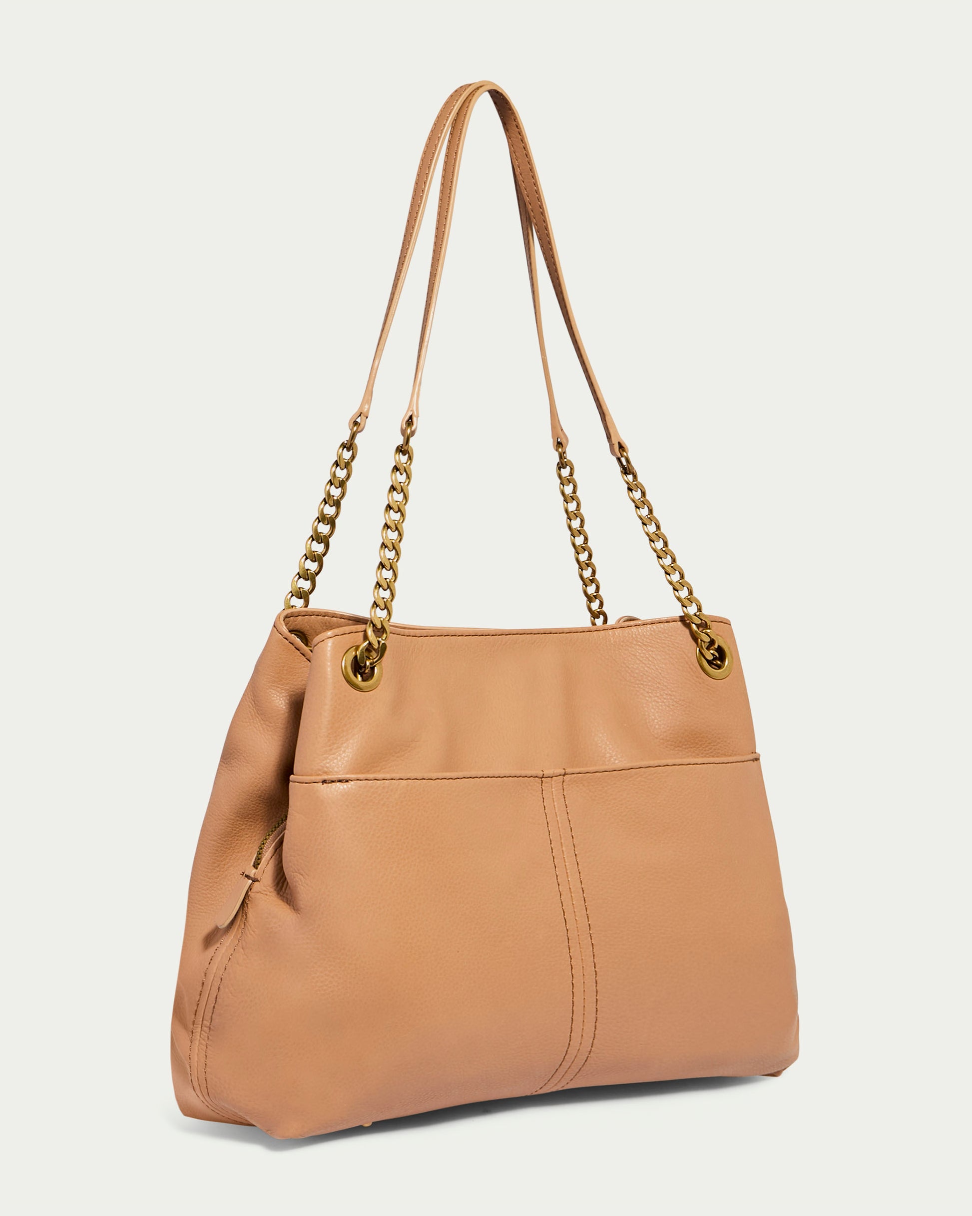 The Brisben Chain Shopper by American Leather Co. is a stylish tan-colored Genuine Leather bag with gold chain and leather shoulder straps. It showcases a smooth texture with subtle stitching and features a spacious interior. Two metal grommets on the front allow the Lightweight Chain straps to slide through for added style.