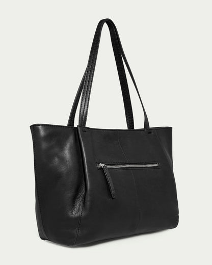 The Lindley Tote by American Leather Co. is a genuine leather black tote bag featuring padded straps and a front zipper pocket. With its sleek and smooth surface, the bag offers a classic and versatile design perfect for everyday use.