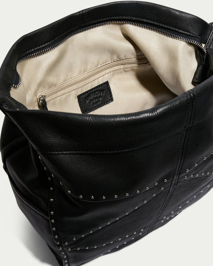 Introducing the Locke Ziptop Studded Hobo by American Leather Co., an open black genuine leather shoulder bag adorned with fashionable stud detailing. The interior is lined with beige fabric, featuring a zipped pocket and a visible brand label, offering both stylish and modern design elements.