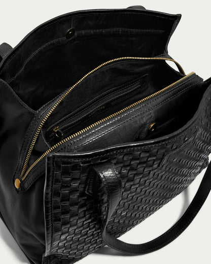 The Sandy Woven Triple Entry Satchel by American Leather Co. is a stunning black leather handbag featuring an intricate woven exterior and multiple compartments. It includes a main compartment with a zippered pocket, an additional smaller pouch inside, and black fabric lining. The handles enhance both its elegance and functionality.