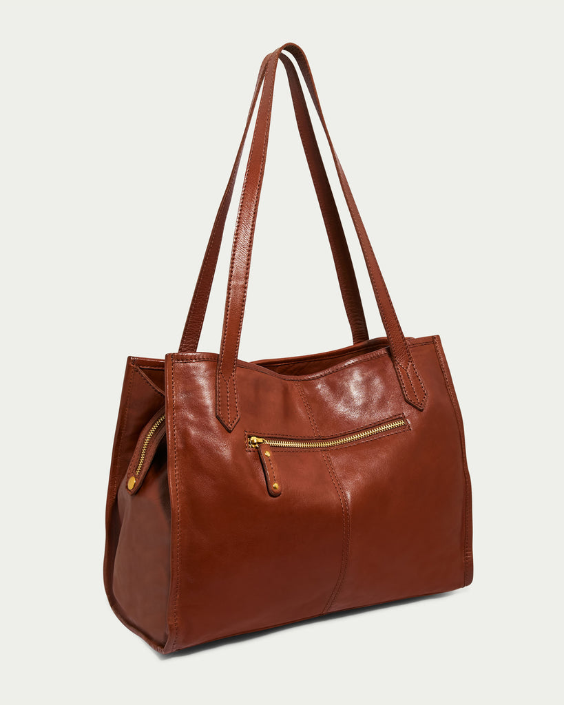 The Sandy Woven Triple Entry Satchel is a brown leather handbag with double shoulder straps from American Leather Co. This Genuine Leather Bag features a front zippered pocket with a gold zipper and sleek stitching. The handbag has a classic, elegant design by Heritage By American Leather, suitable for everyday use or special occasions.