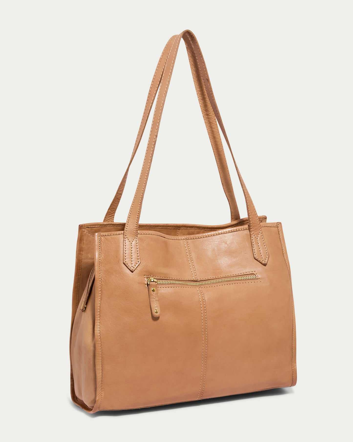 The Sandy Woven Triple Entry Satchel from American Leather Co. is a tan genuine leather shoulder bag with double straps. It features a front zipper pocket with a small zipper pull. The design is simple and elegant, suitable for daily use. The background of the image is light and plain, highlighting its timeless appeal.