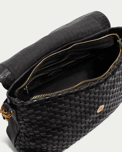 A top-down view of an open black Summers Woven Crossbody by American Leather Co. reveals a genuine leather handbag with intricate gold zipper detailing and a secure magnetic snap closure. The interior, lined in black fabric, boasts several compartments and pockets, easily accessible through the open top. This limited edition crossbody adds a touch of luxury to your collection.