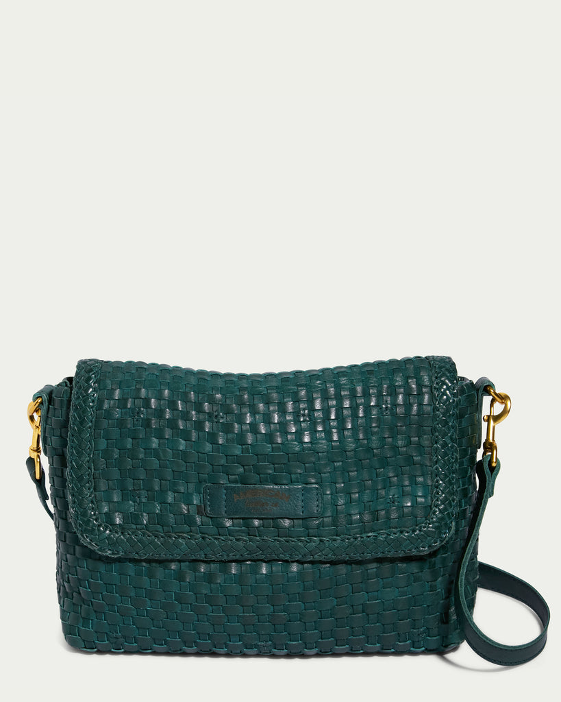 The Summers Woven Crossbody from American Leather Co. is a dark green, genuine leather bag with a woven texture. This stylish and elegant accessory features a flap closure, gold hardware, and an adjustable strap.