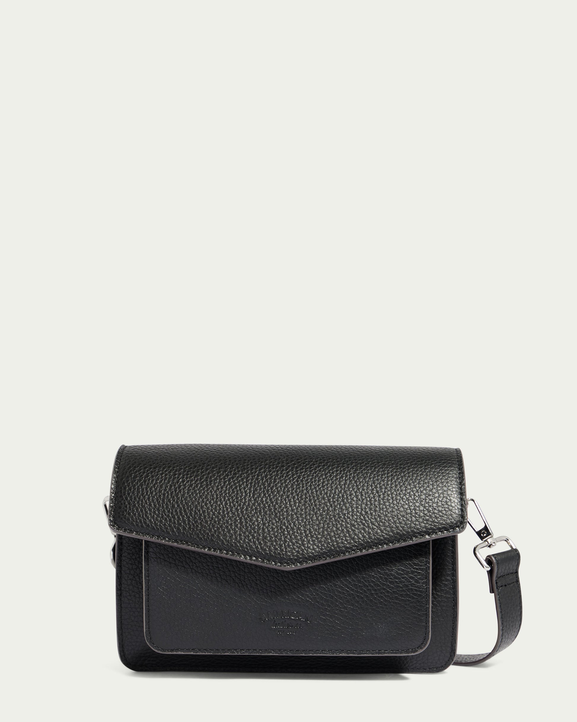 Introducing the Troy Acordian Crossbody by American Leather Co.—a black genuine leather bag with a textured finish, featuring an envelope-style flap closure, a small front pocket, and minimalistic hardware. This weather-proof crossbody bag also includes an adjustable strap for versatile wear.