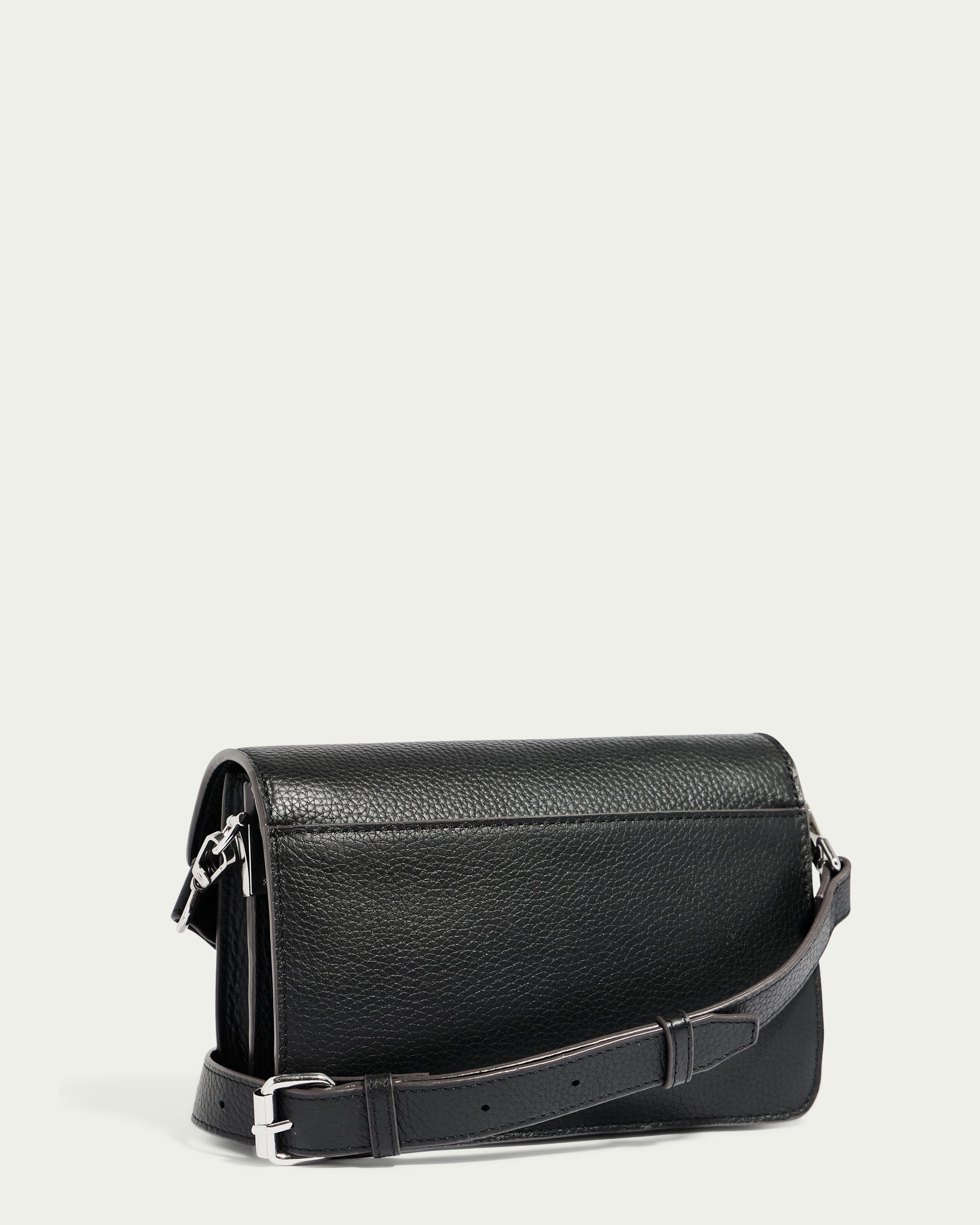 The Troy Acordian Crossbody by American Leather Co. is a sleek, black weatherproof leather bag featuring a silver buckle on an adjustable strap. With its smooth black texture and flap closure, this bag exudes a minimalist and modern aesthetic against a plain light gray background.