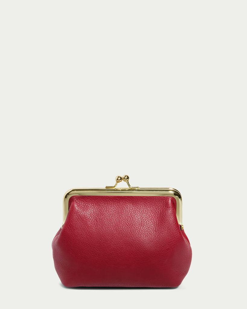 The Wolfe Frame Kisslock With CC Slots from American Leather Co. is a small red leather coin purse featuring a classic clasp closure at the top, and adorned with a gold-tone metal frame. This genuine leather accessory from the Cleveland Collection is showcased against a plain, light-colored background.