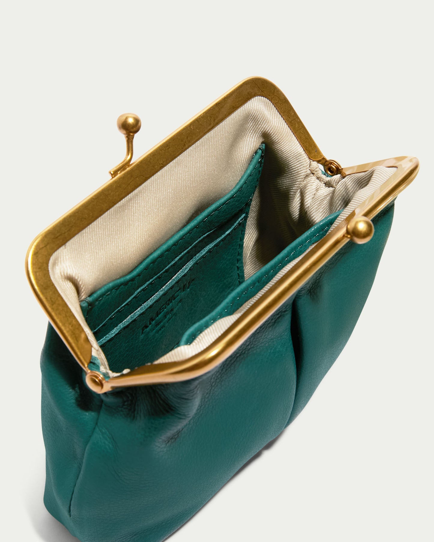 This compact, open green leather coin purse from the Cleveland Collection by American Leather Co. showcases a durable gold frame and clasp. The kisslock wallet's interior is lined with light fabric and includes two convenient compartments.