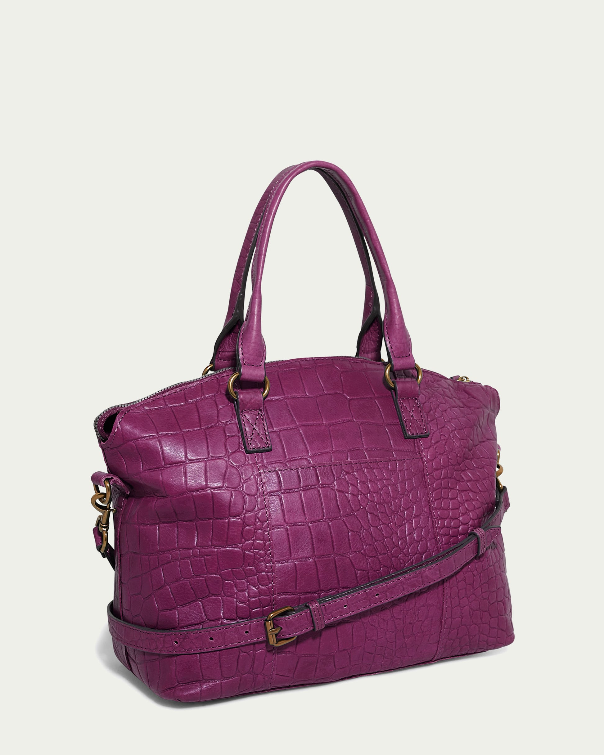 The Carrie Dome Satchel by American Leather Co. is a purple handbag crafted from textured crocodile-patterned leather. It features two handles, a detachable shoulder strap, gold-tone hardware, a zippered top, and boasts a beautifully structured design made from genuine American leather.