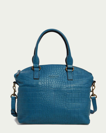 The Carrie Dome Satchel from American Leather Co. is elegantly crafted from Genuine American Leather with a striking crocodile pattern and comes in a beautiful teal-blue hue. It features two top handles, an adjustable crossbody strap adorned with gold-tone hardware, and a zippered main compartment. The brand name is embossed on the front for an added touch of sophistication.