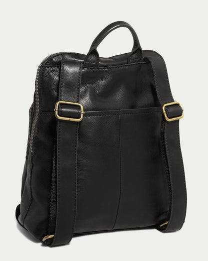 The Cleveland Backpack by American Leather Co. is a black leather backpack made from genuine American leather, with adjustable back straps, gold buckles, and a smooth material. Its simple design includes a top handle at the center and is displayed with the back facing the viewer.