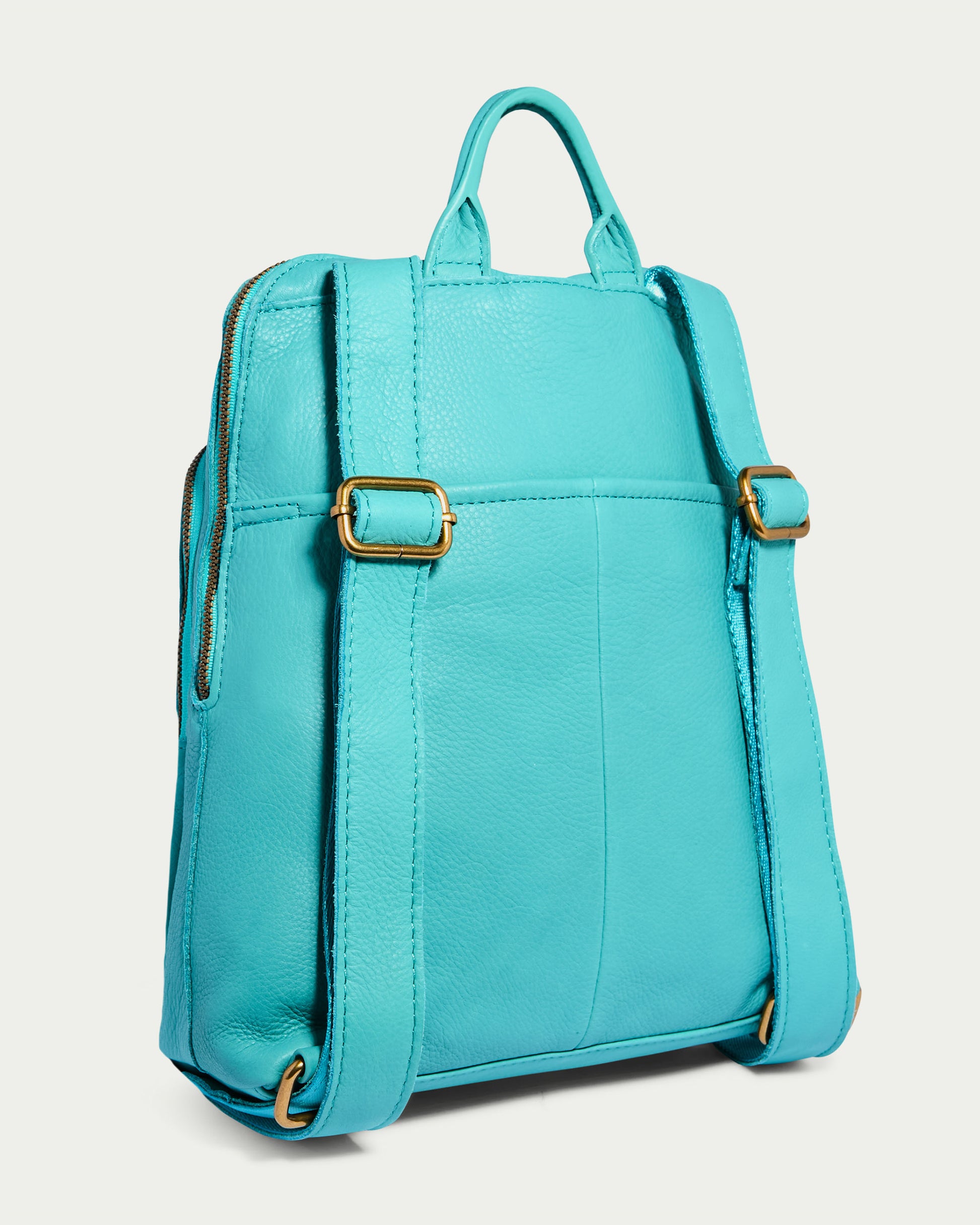 Introducing the Cleveland Backpack by American Leather Co., a vibrant turquoise genuine leather backpack purse adorned with gold buckles and zippers. It features a convenient top handle and adjustable back straps, beautifully displayed against a light background to highlight its stylish and modern design.