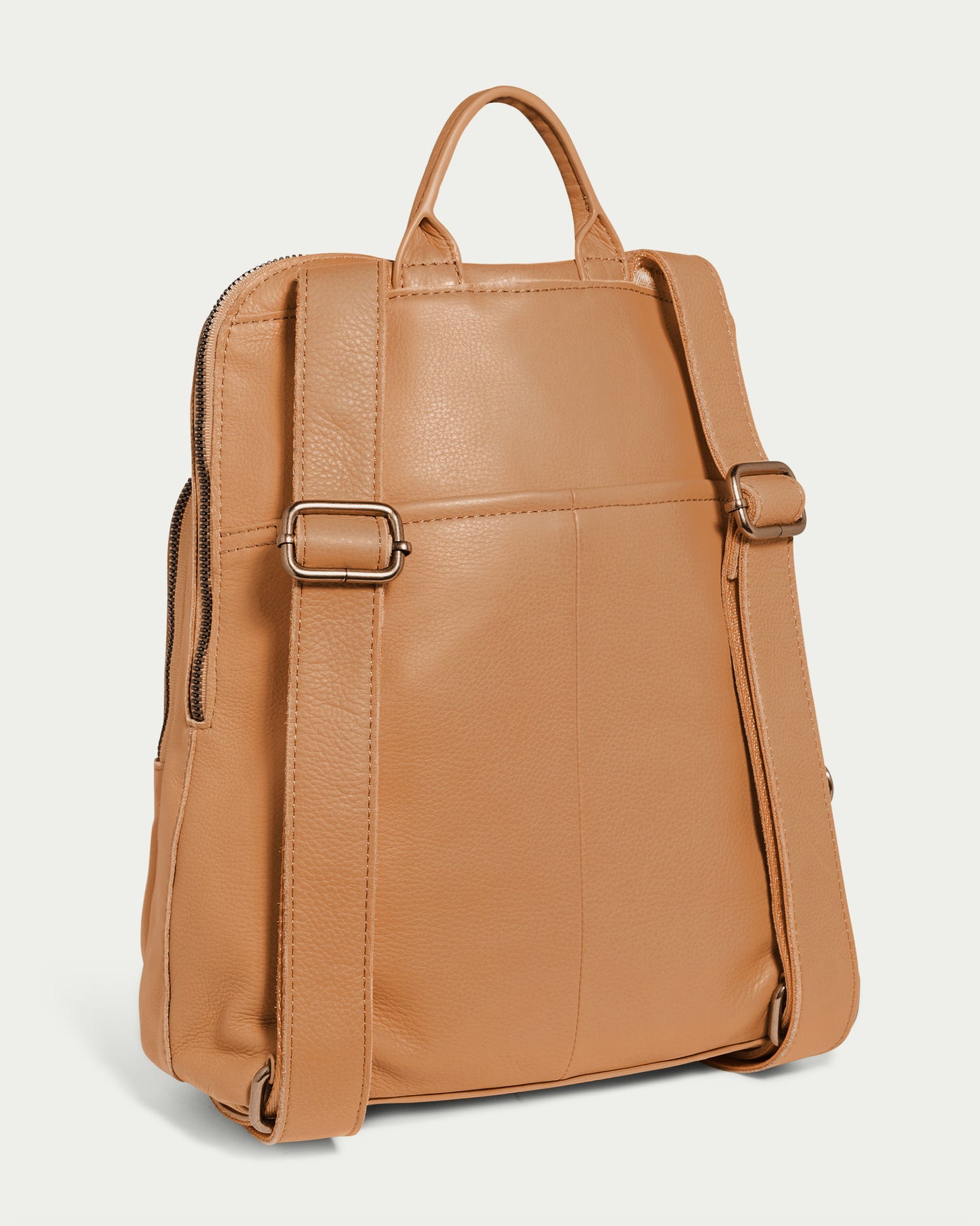 The Cleveland Backpack from American Leather Co. is a tan genuine leather bag with two adjustable straps and a top handle, shown from the back. It boasts a sleek design with a zip compartment on the left side and has smooth, slightly pebbled leather.