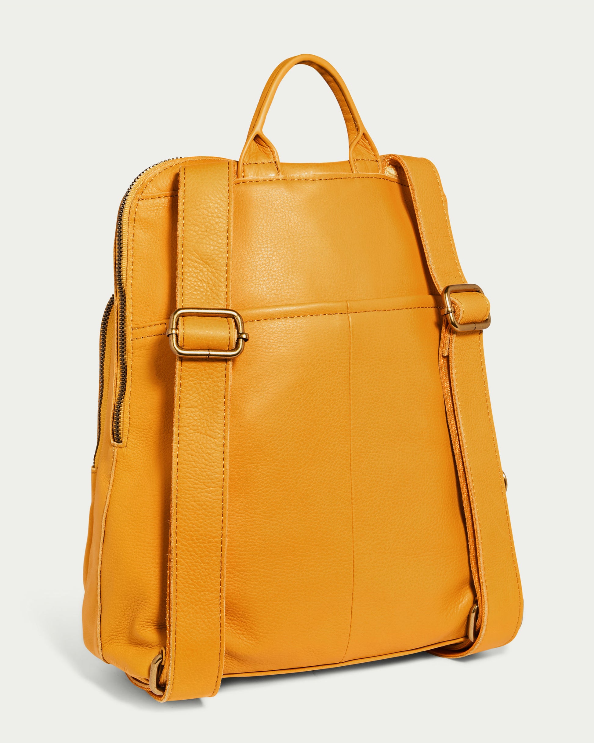 The Cleveland Backpack by American Leather Co. is a chic yellow leather backpack purse featuring adjustable straps and a top handle. Made from genuine leather, this bag has a zippered closure along the side and boasts a sleek, smooth texture. It stands upright, showcasing its unique back and strap design.