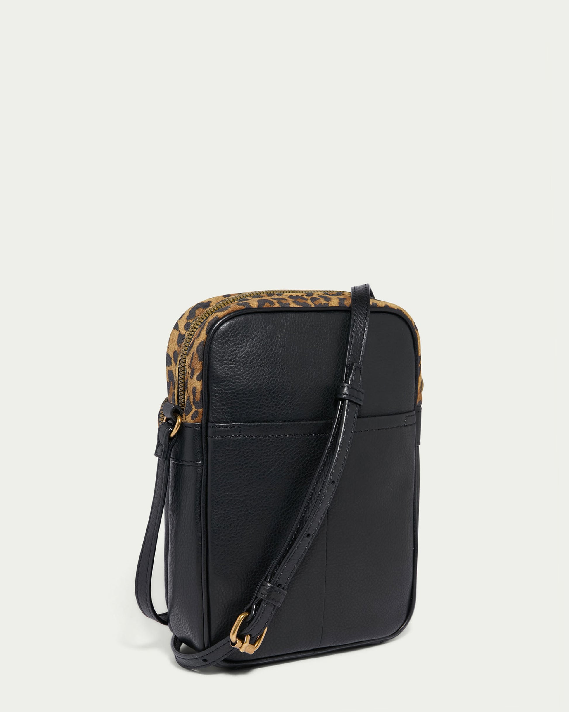 The Cleveland Large NS Crossbody by American Leather Co. showcases a chic black leather design with brown leopard print trim, featuring a slim rectangular shape and an adjustable strap for versatility.