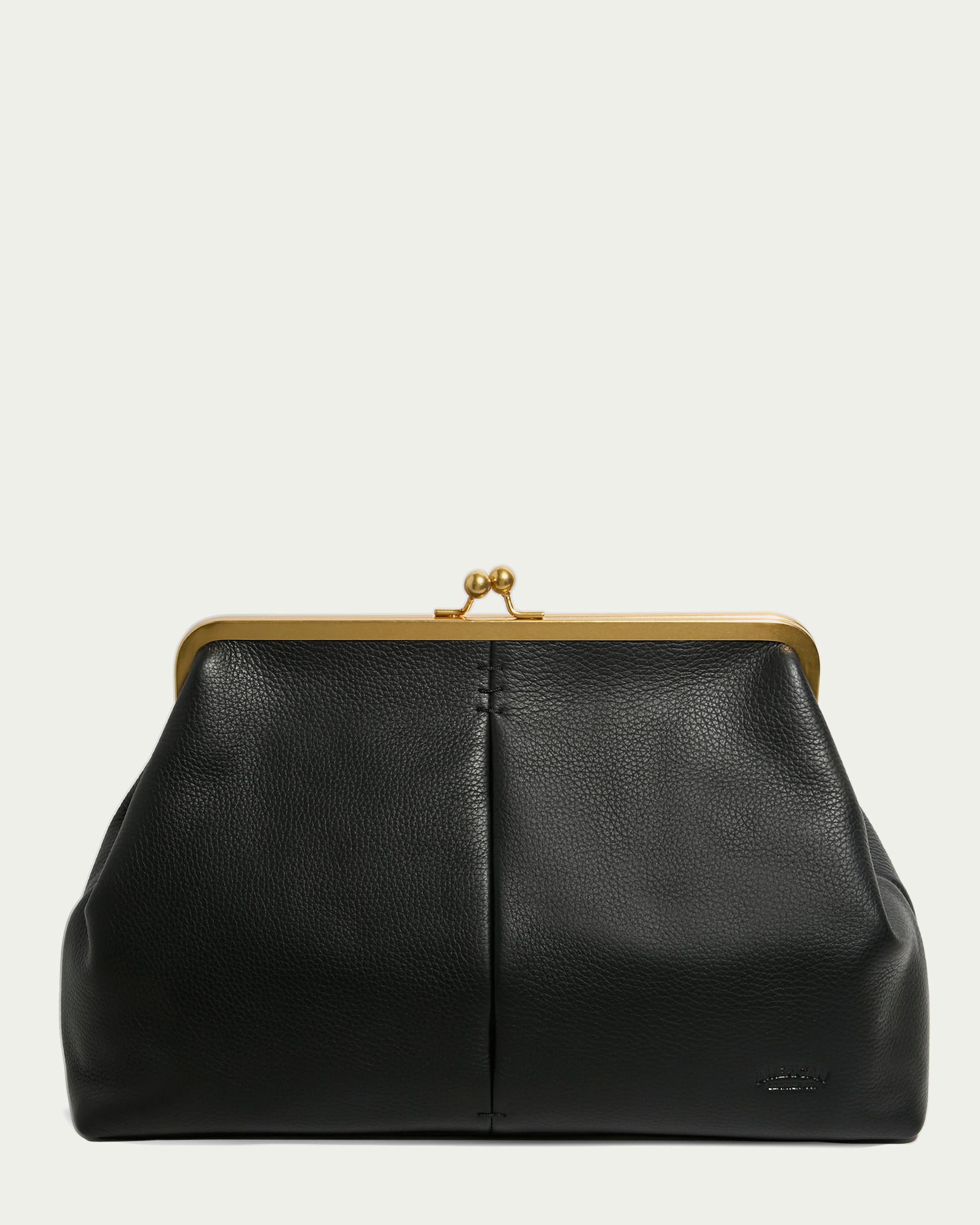 The Grace Oversized Clutch by American Leather Co. is a black leather handbag with a gold clasp and frame, featuring a textured surface and structured design. Its classic elegance is enhanced by a convenient wristlet strap for effortless style.