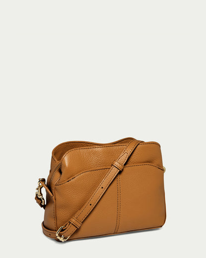 The Tulip Triple Entry Crossbody by American Leather Co. is crafted from genuine leather and features a long adjustable strap with gold hardware, presented against a plain white background.