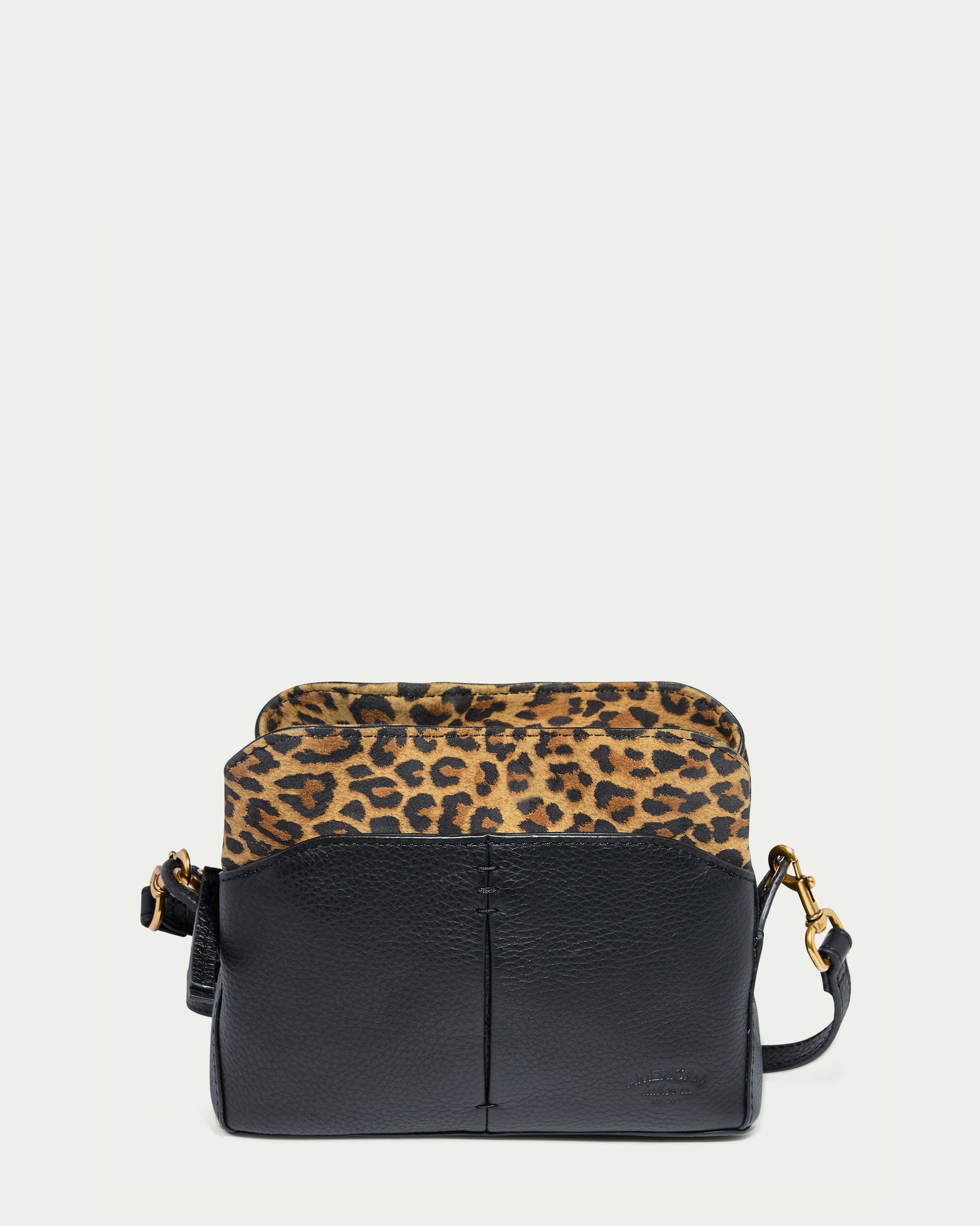 The Tulip Triple Entry Crossbody by American Leather Co. showcases a chic and modern design with its black genuine leather base and leopard print flap. It features a wide, adjustable black shoulder strap and subtle gold-tone hardware, making it perfect for both casual and formal occasions.