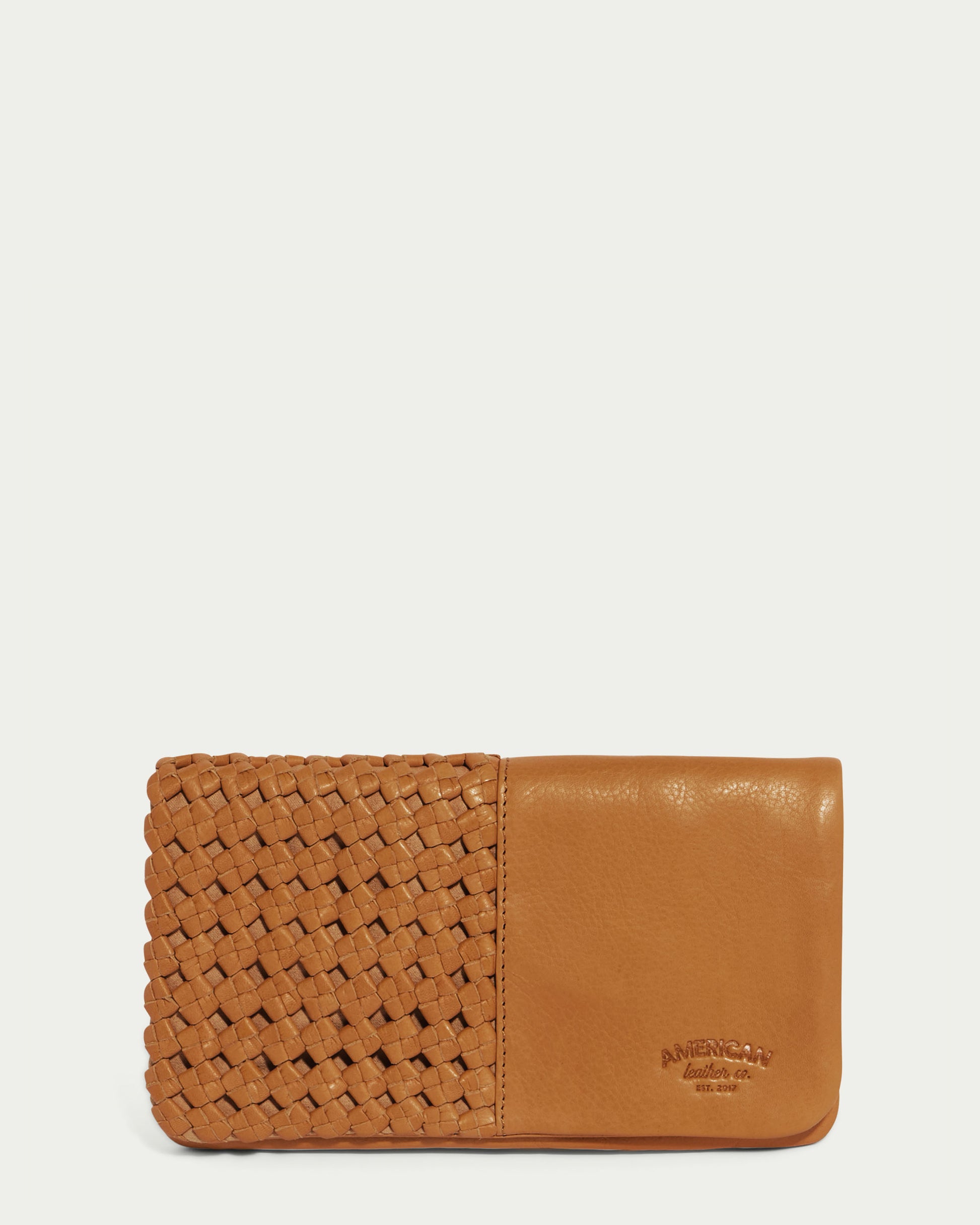 A Cafe Latte Webster Woven Bifold Wallet featuring woven details on the left side and smooth, supple leather on the right. The American Leather Co. brand name is elegantly embossed on the bottom right corner.