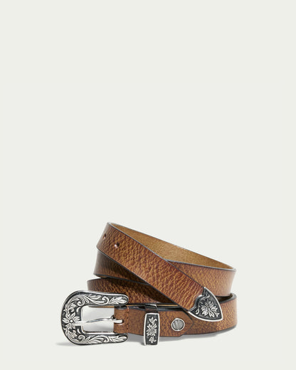 The Hamilton Belt by American Leather Co. is a brandy-colored leather belt showcasing polished hardware and a decorative silver buckle with intricate floral engravings, coiled in a spiral against a plain white background, highlighting its rich texture and exquisite craftsmanship.