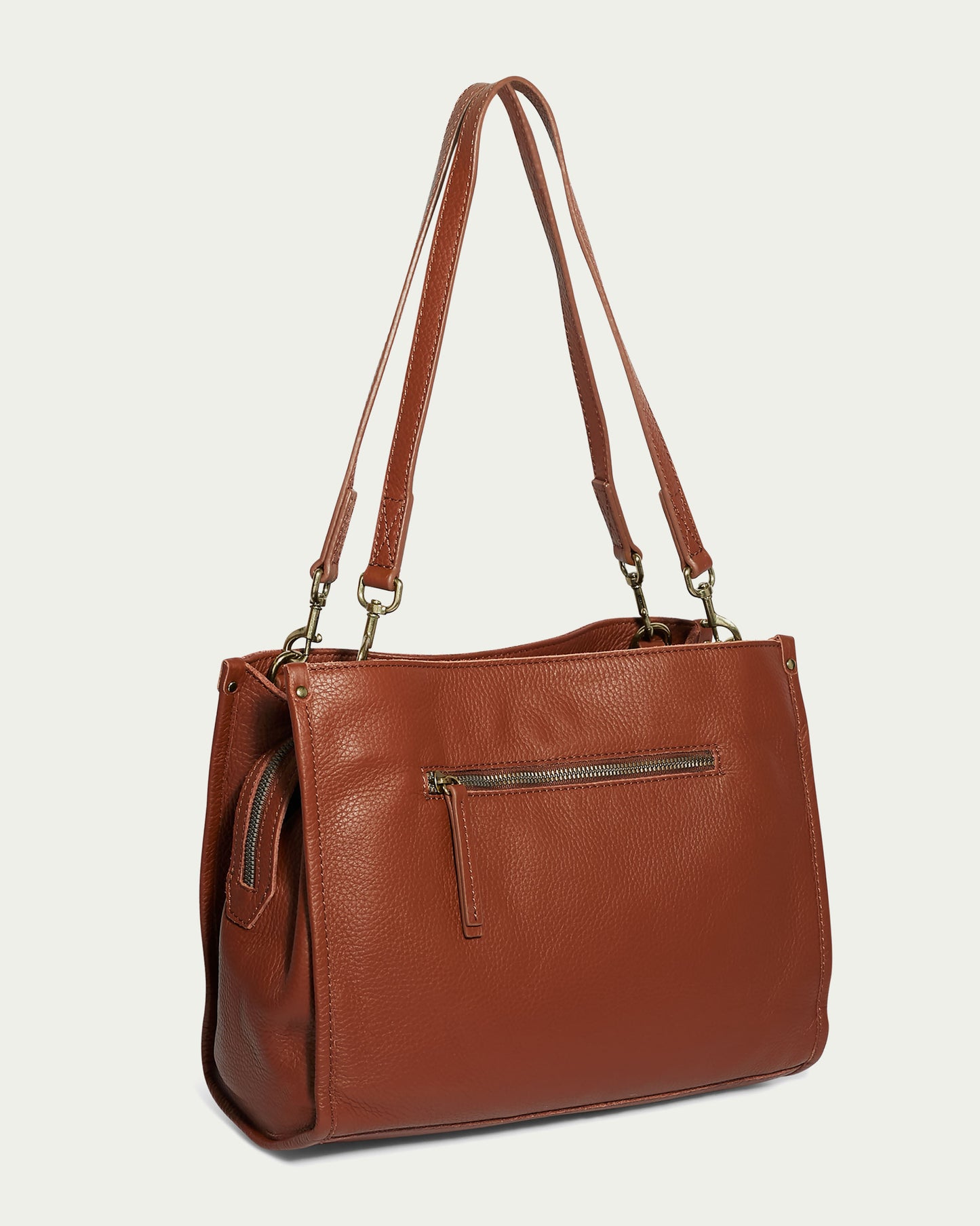 The Lenox Triple Entry Satchel by American Leather Co. is a stylish brown leather tote crafted from Genuine American Leather. It features long handles, a zippered front pocket, metal hardware, and a textured finish, displayed against a plain off-white background.