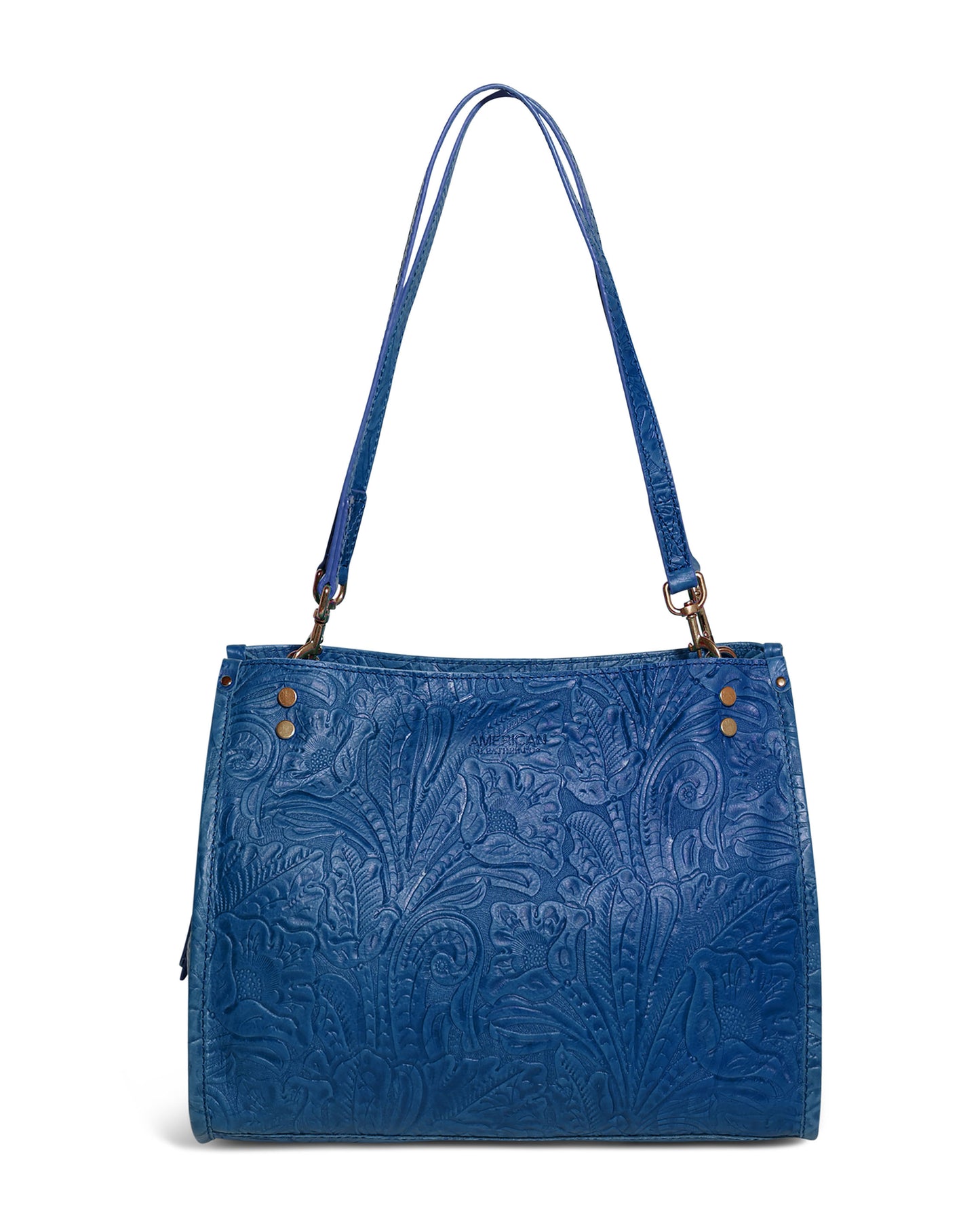 The Lenox Triple Entry Satchel by American Leather Co. is a blue leather handbag crafted from genuine American leather. It features embossed floral patterns and two handles, with metal studs near the handles adding decorative flair. The texture provides a stylish and sophisticated look to this everyday essential.