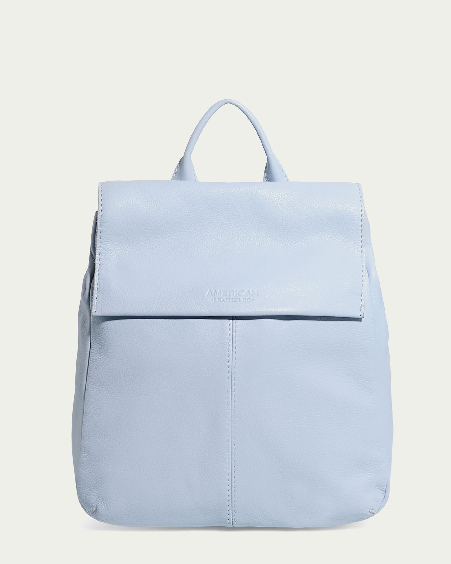 The Liberty Backpack by American Leather Co. is a light blue women's leather backpack made from genuine American leather. It features a flap closure, top handle, embossed brand name on the flap, adjustable straps, and a minimalistic design perfect for any occasion.