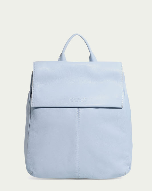 The Liberty Backpack by American Leather Co. is a light blue women's leather backpack made from genuine American leather. It features a flap closure, top handle, embossed brand name on the flap, adjustable straps, and a minimalistic design perfect for any occasion.