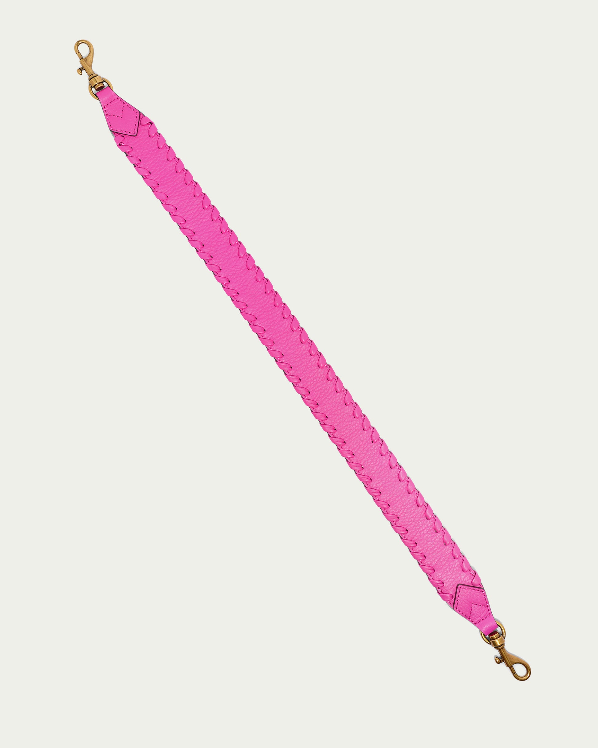 The Luca Strap from American Leather Co. showcases a vibrant pink color with a braided design pattern. It includes gold-colored swivel clasps on both ends, perfect for attaching to a Luca crossbody bag. The strap is displayed laid out flat against a plain, light-colored background.