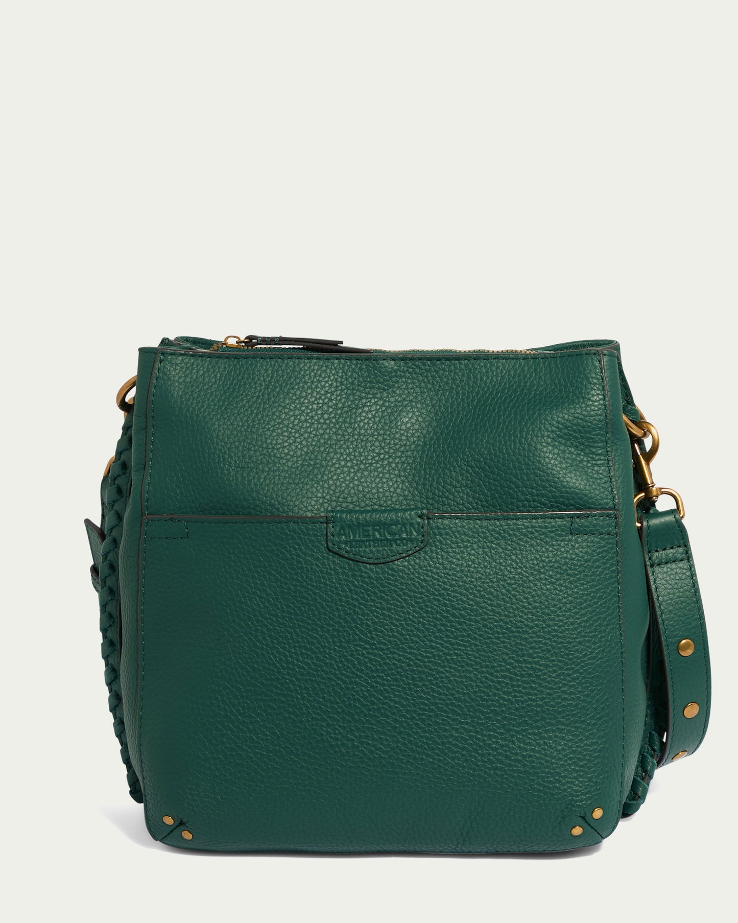 The American Leather Co. Luca Triple Entry Crossbody is crafted from glove-tanned pebble leather in a rich green hue. It features a front pocket, gold-tone hardware accents, and a main compartment with a zipper closure. Completing the design is an adjustable/removable crossbody strap and a braided detail on one side.