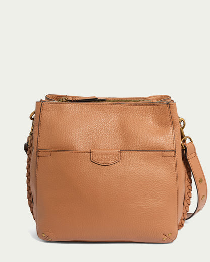 The Luca Triple Entry Crossbody by American Leather Co. is a glove-tanned leather crossbody bag featuring a pebbled texture and gold hardware. It includes a top zipper closure, triple entry compartments, a front pocket, and a detachable shoulder strap with braided detailing. The brand name is embossed on the front, set against a plain white background.