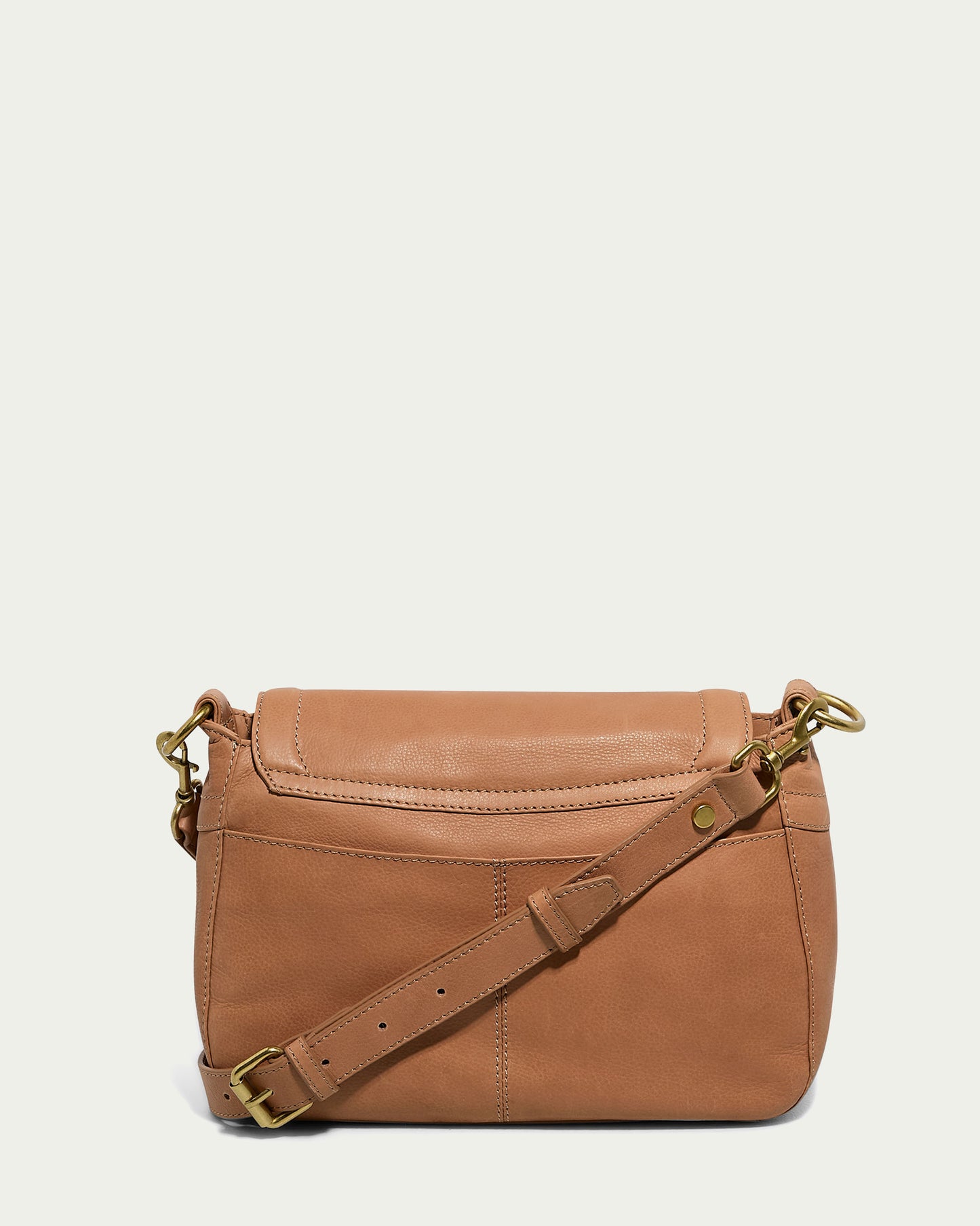 The Marino Crossbody with 2 Straps by American Leather Co. is beautifully crafted from butter-soft leather, featuring brass hardware and an adjustable strap. The design includes a fold-over flap secured by a magnetic snap and a back slip pocket. Additionally, the strap boasts a brass buckle and a small decorative tag near the hardware, all showcased against a plain white background.