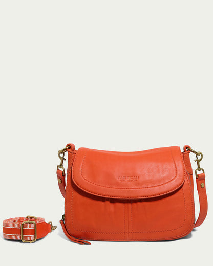 The Marino Crossbody with 2 Straps is an orange leather bag featuring a front flap and brass metal hardware. Crafted from premium leather, it boasts a detachable, adjustable shoulder strap with a striped design. The brand name "American Leather Co." is embossed on the front flap, highlighting its functional design.