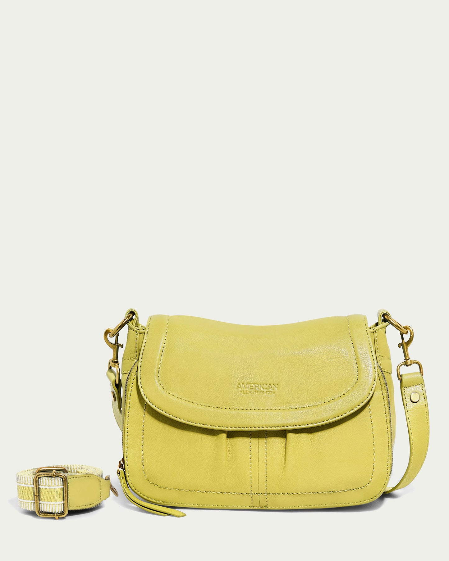 A lime green Marino Crossbody with a flap closure is showcased against a light background. This chic accessory, crafted from premium leather, features a functional design with a detachable shoulder strap and displays the embossed brand name "American Leather Co." on the front.